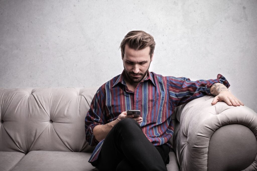 Homem no sofá atento ao celular
