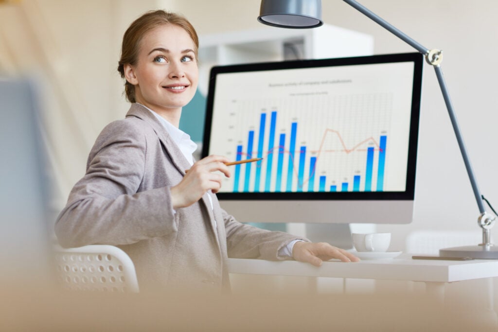 Mulher com gráficos na tela vendo gráficos sobre o mercado e entendendo como ser trader em portugal