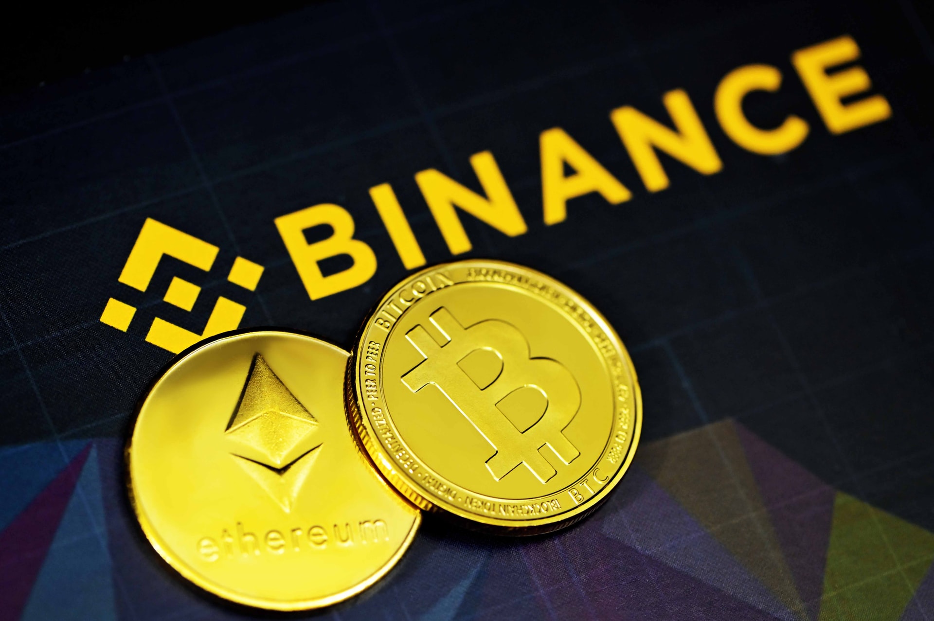 Logotipo Binance com moedas digitais Bitcoin e Ethereum