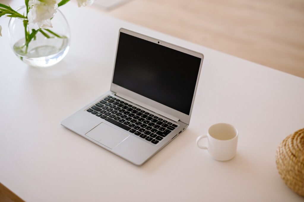 Vas d plantas com água e caneca sobre a mesa. Também sobre a mesa um notebook, que pode ser utilizado para solicitar crédito BBVA.