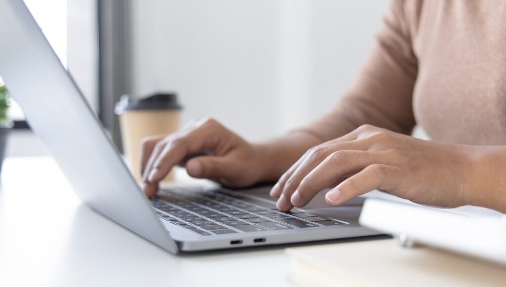 Pessoa usando notebook, simbolizando como simular e contratar o crédito Reorganiza online