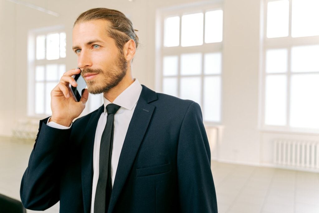 homem de terno e gravata falando ao celular