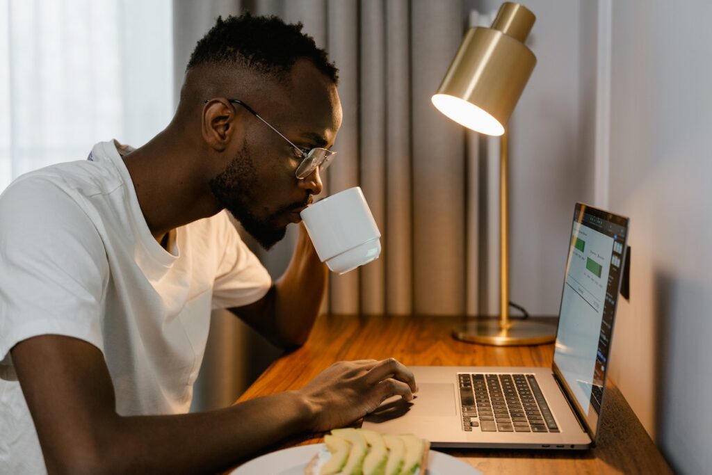 Pessoa com um notebook e uma xícara de café lendo informações sobre a plataforma moneezy