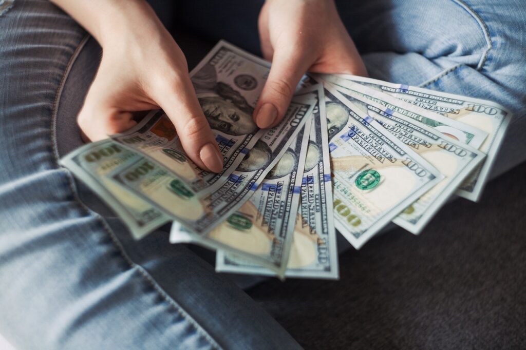 imagem com uma pessoa segurando várias notas de dinheiro a partir de um crédito do banco montepio