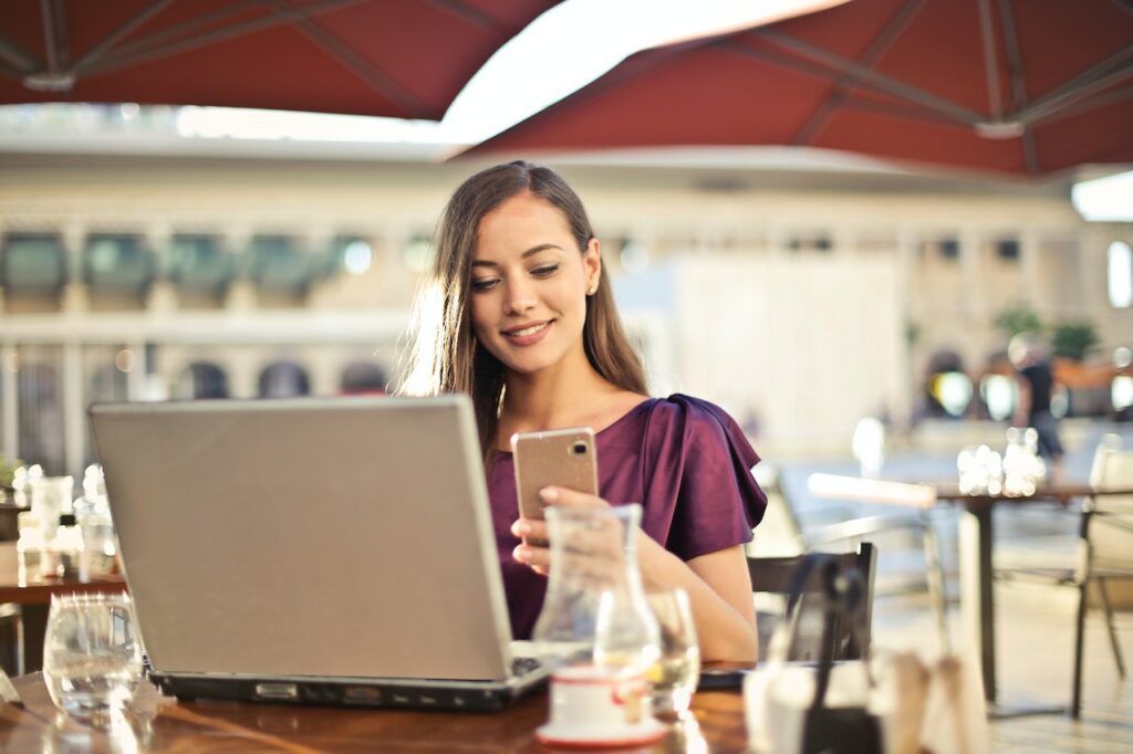imagem de uma mulher pesquisando no celular o review do Banco EuroBic