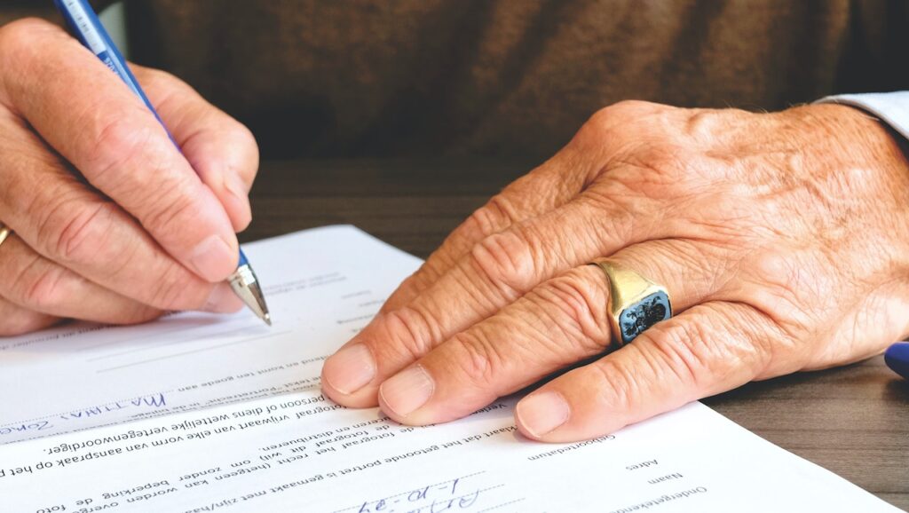 pessoa assinando um contrato de mediação imobiliária