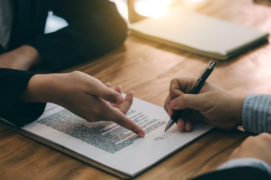 duas pessoas assinando contrato de emprego