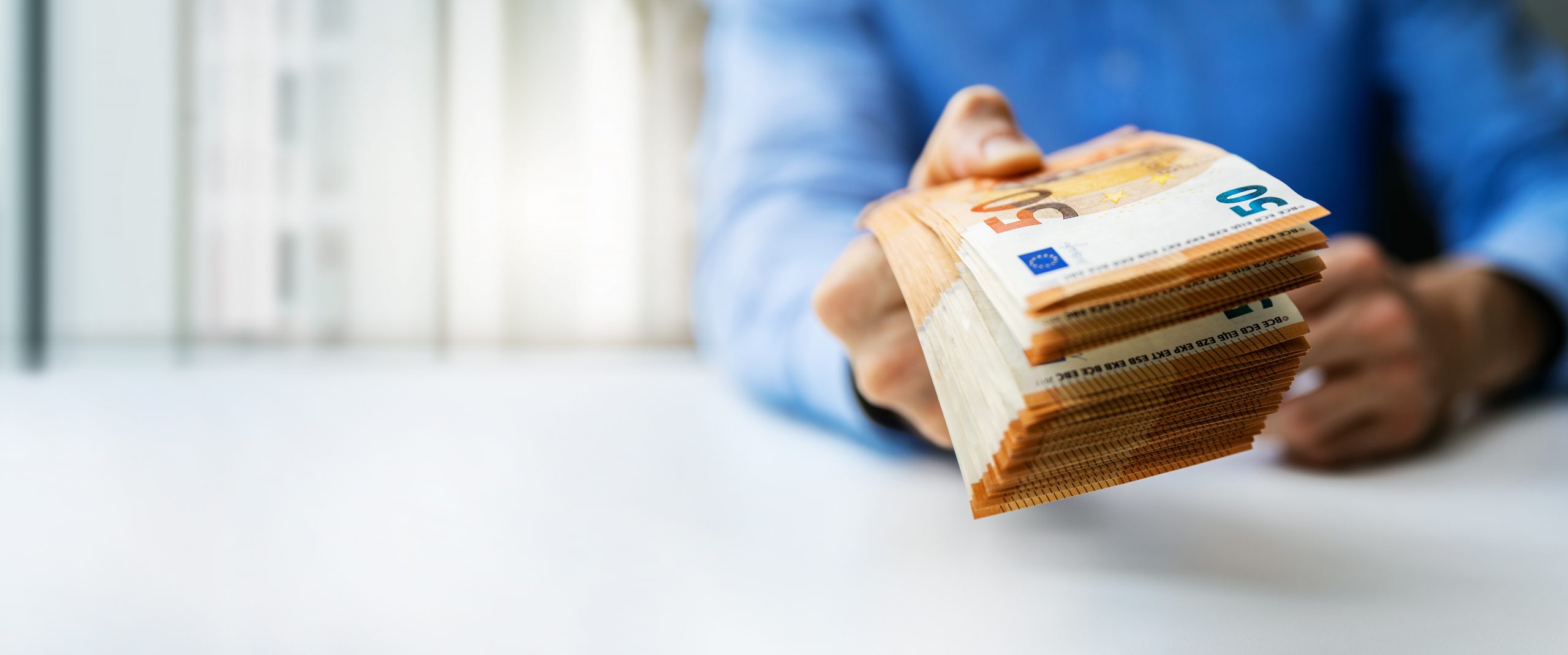Mão oferecendo notas de euro