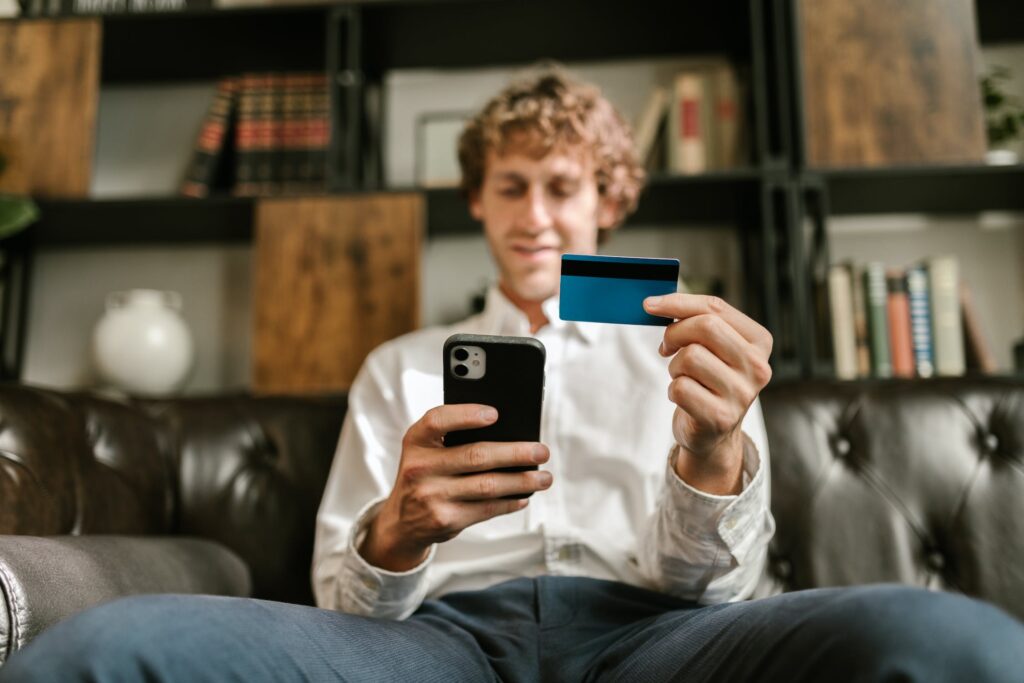 Homem olhando celular e cartão