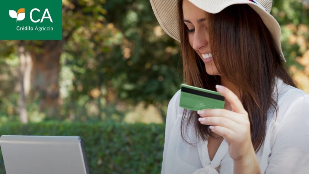 Mulher com cartão na mão olhando notebook