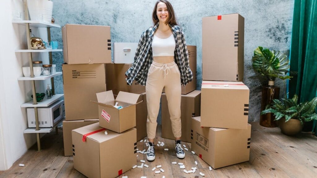 Jovem feliz rodeada de caixas de mudança