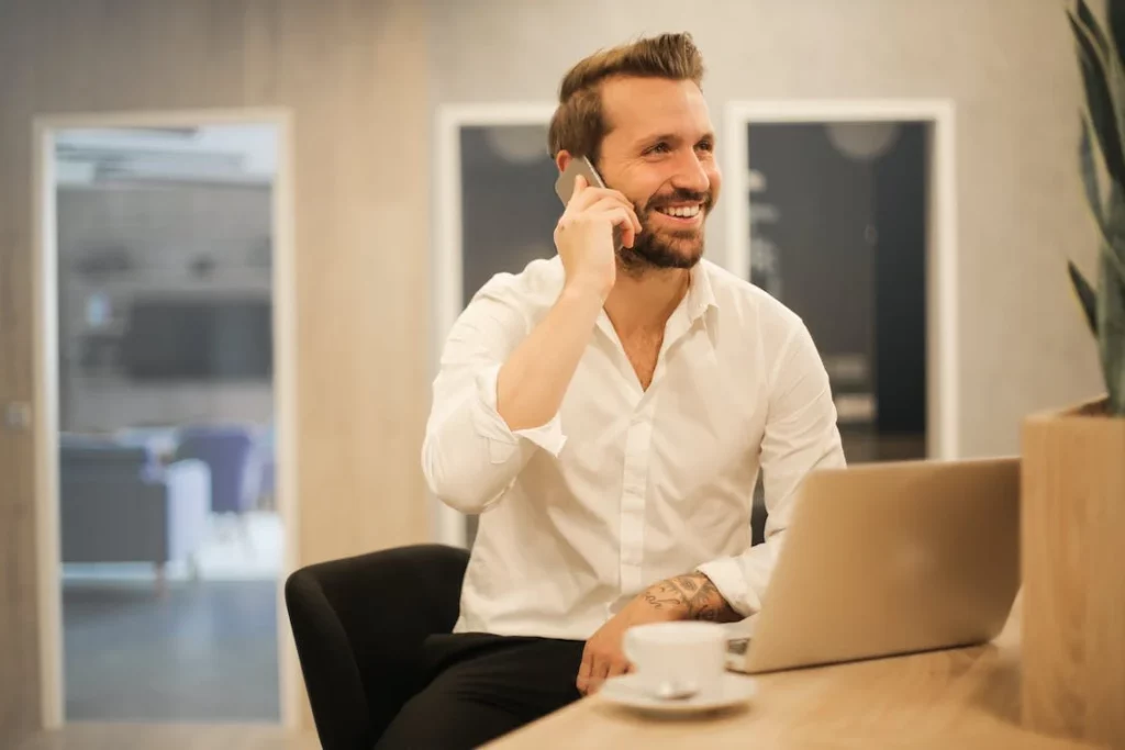 Homem falando ao telefone e sorrindo