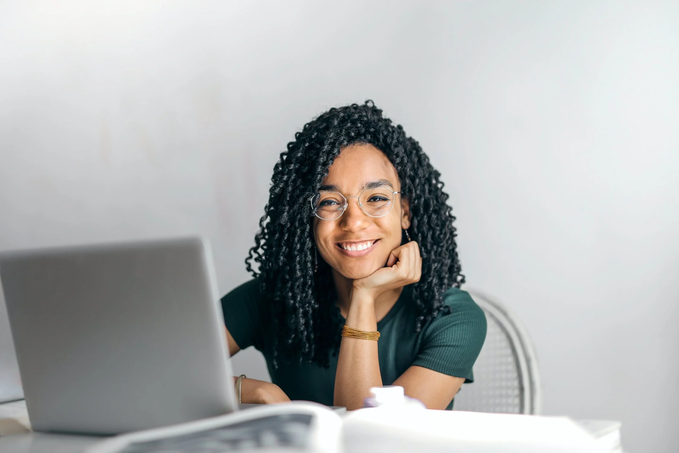 Menina jovem sorrindo em frente ao notebook