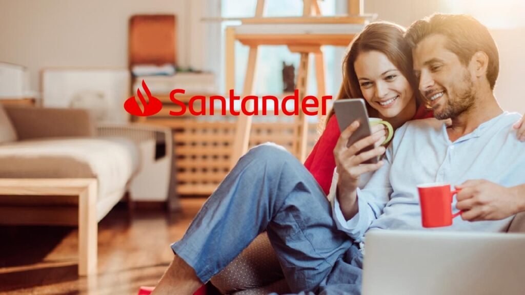 Casal sentado no chão de casa vendo celular e sorrindo