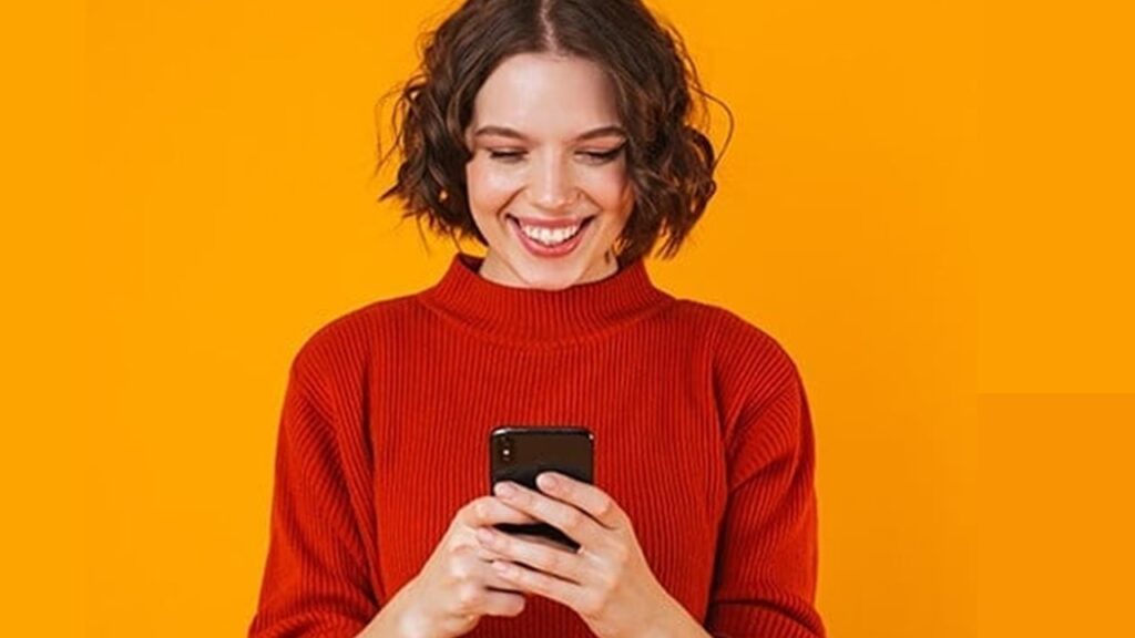 Mulher sorrindo olhando celular