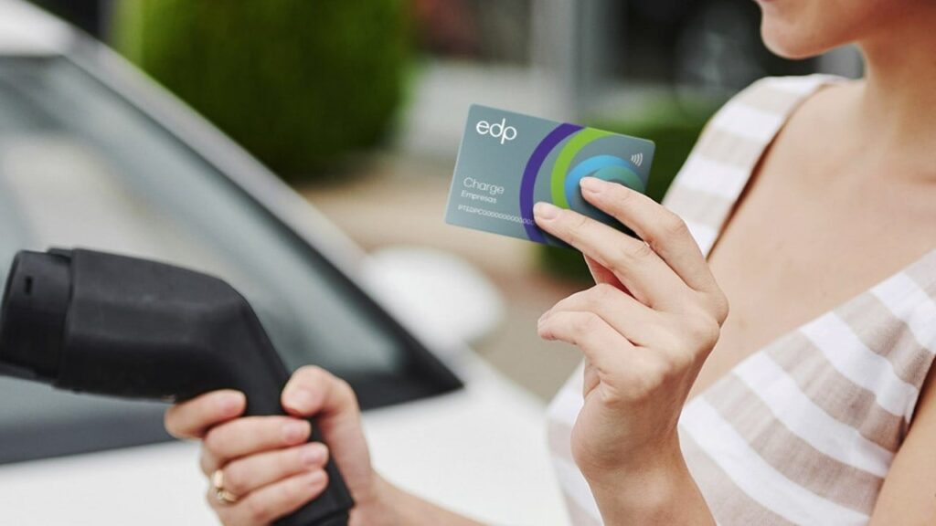 Mulher segurando cartão EDP e recarregando carro elétrico