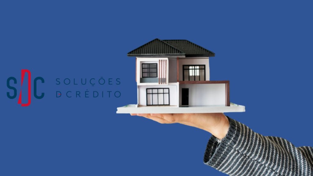 Mão segurando miniatura de casa