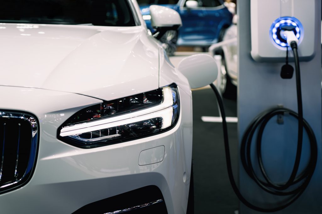 Carro elétrico de frente, ligado a estação para carregar
