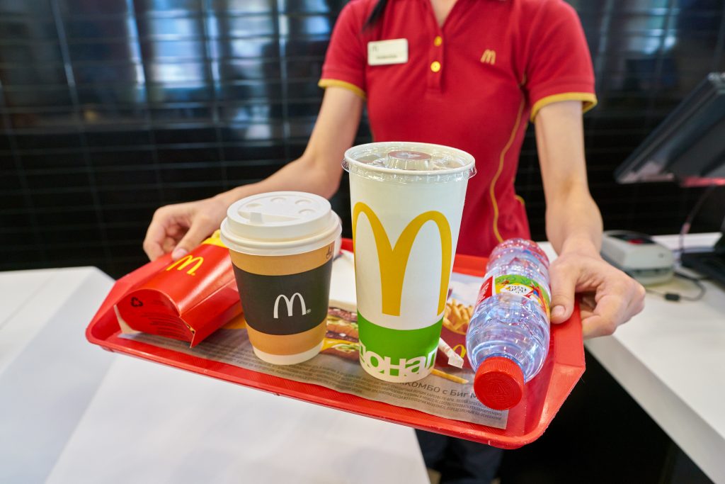 Atendente do McDonald's entregando bandeja