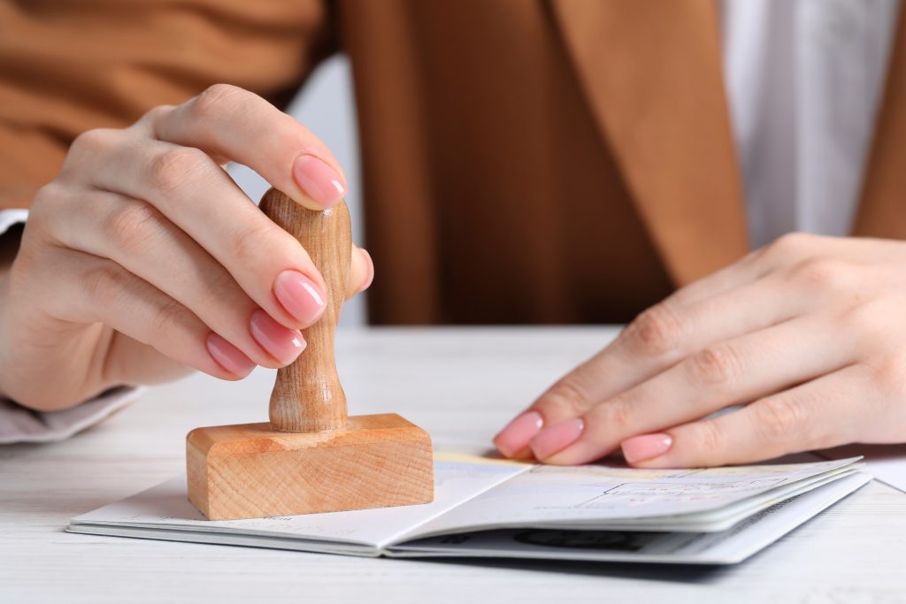 Mãos femininas carimbando um passaporte