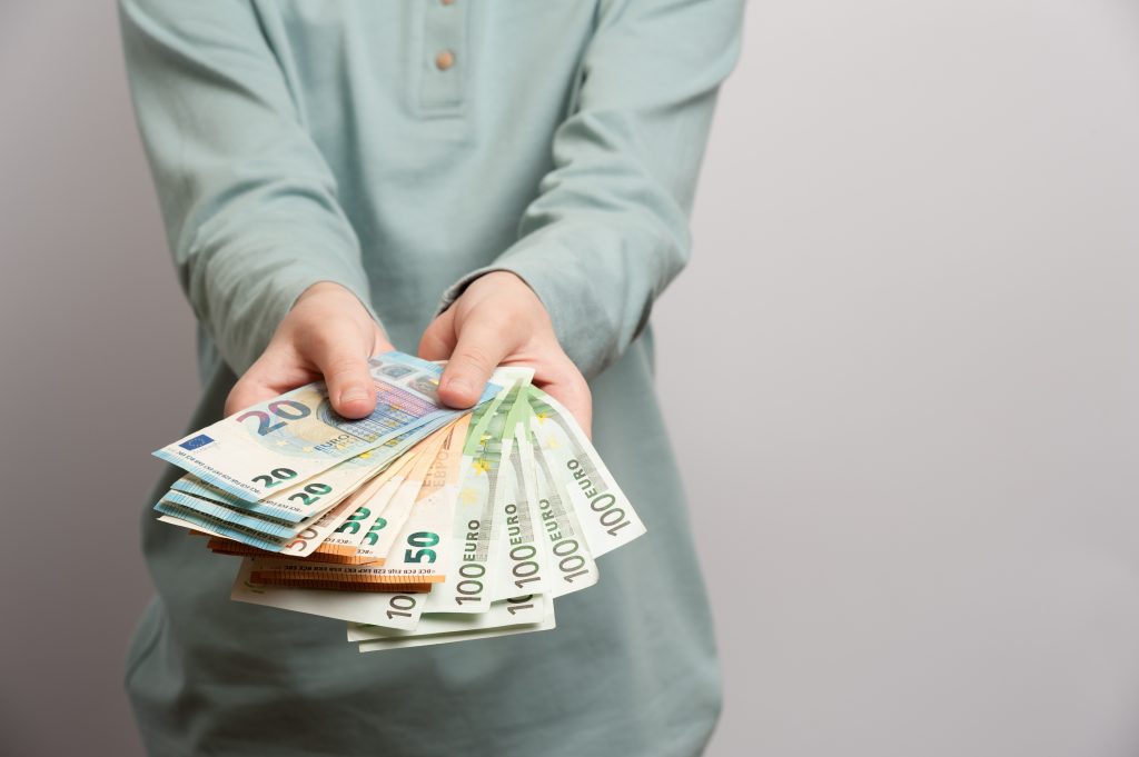 Mãos segurando notas de euro