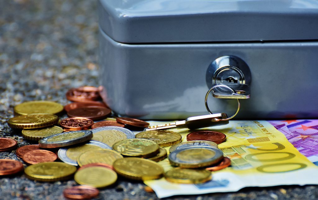 Caixa com moedas e notas de dinheiro sobre a mesa