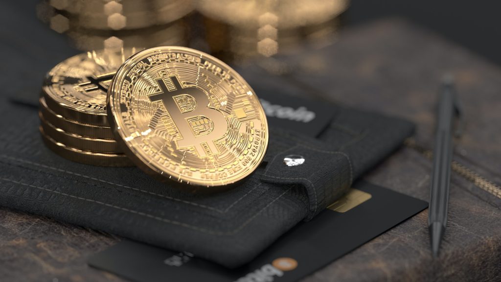 Bitcoins sobre carteira com cartões de crédito, representando operações financeiras em corretoras de criptomoedas portugal